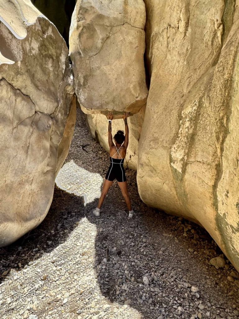 Canyon Hike Mallorca climber lifting rock in narrow canyon, adventure trekking and extreme outdoor challenge