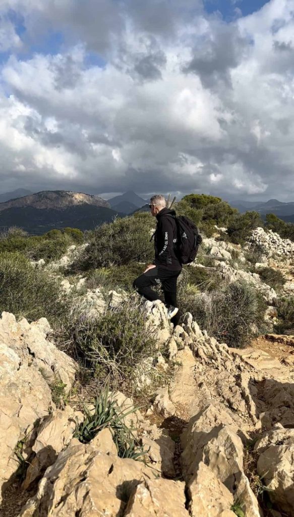 Monjo Hike Mallorca: hiker on rugged mountain trail with natural terrain and scenic Tramuntana landscape views